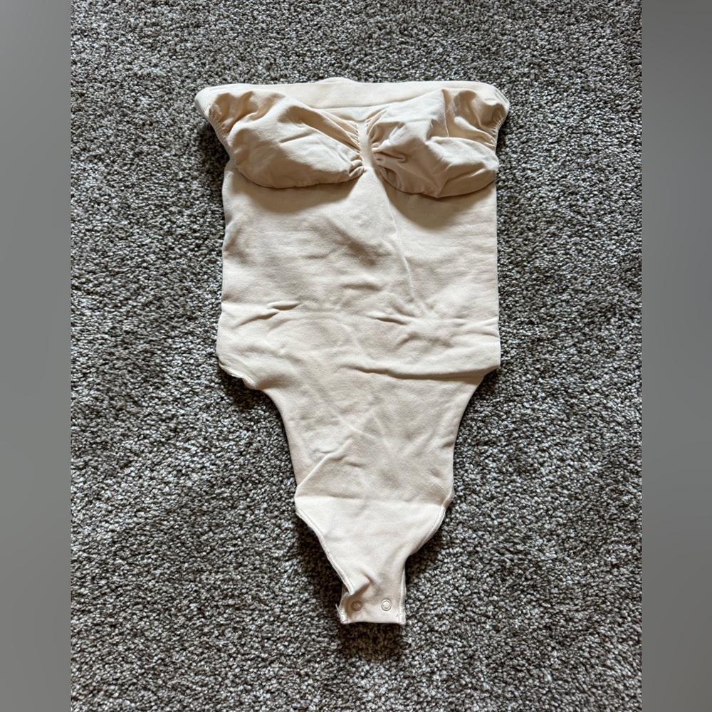 SKIMS SEAMLESS SCULPT STRAPLESS THONG BODYSUIT - SAND